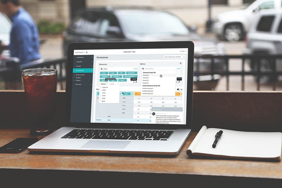 Realistic mockup of person using Predictiva on laptop in the café terrace with a notebook